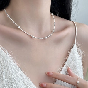 Minimalist silver necklace and pearl ring set on model with white fringe top