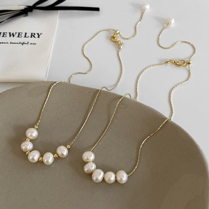 Detail of five freshwater pearls arranged on a fine gold-plated adjustable chain necklace