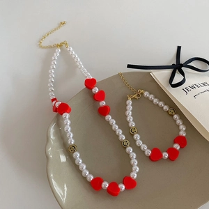 Ensemble collier et bracelet en perles avec cœurs rouges et perles sourire dorées