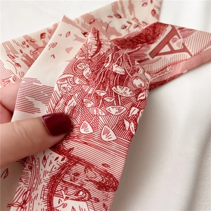 Détail d'un foulard en soie avec motif floral rouge et lettre A imprimée élégante
