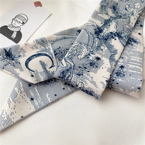 Détail d'un twilly blanc étroit avec imprimés bleus d'astrologie et de licornes