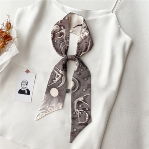 Détail du foulard Twilly marron café avec imprimés artistiques de soleil et de lune