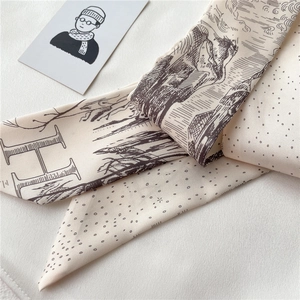 Vue détaillée du foulard en soie crème avec motif de lettre H et couture délicate