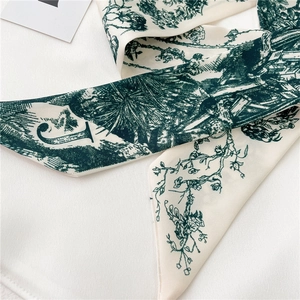 Détail de l'écharpe en soie ivoire avec motif Toile de Jouy vert et impression de la lettre J