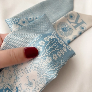 Vue macro du foulard twilly bleu et blanc montrant la texture et le motif floral