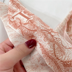 Détail de l'écharpe twilly en soie de qualité avec imprimés floraux et motif lettre D