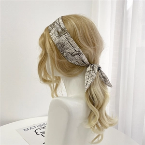 Détail d'un foulard en soie twilly à imprimé nautique noir et blanc porté en ruban