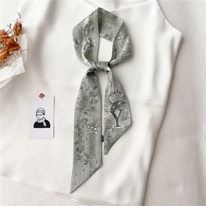 Détail du foulard en soie vert clair avec lettre Y et motifs floraux artistiques
