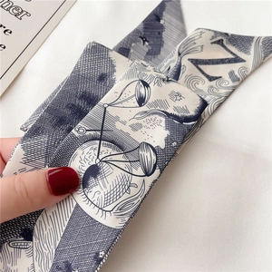 Vue macro d'un foulard en soie avec la lettre N peinte et motifs mythiques
