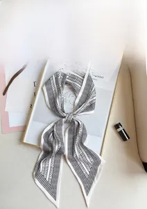Elegant long skinny silk scarf with black geometric leaf pattern in a chic bow knot