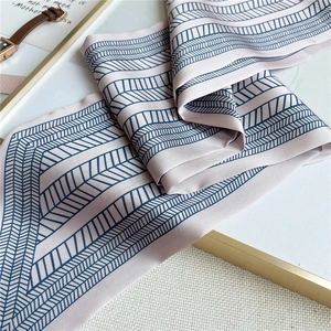 Detail of a pink and blue geometric silk scarf with a modern striped texture and satin finish