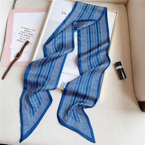 Detail of blue geometric skinny scarf with silk texture and elegant pointed edges