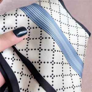 Close-up of geometric pattern silk scarf with contrast edges and smooth texture draping