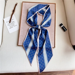 Navy blue geometric print silk scarf tied in a bow on a luxury display setting
