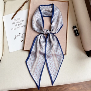 Detail of grey dotted silk necktie scarf featuring navy borders and geometric patterns