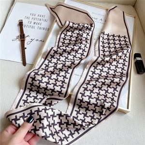 Detail of thin houndstooth silk scarf with pointed ends and stylish accessory styling