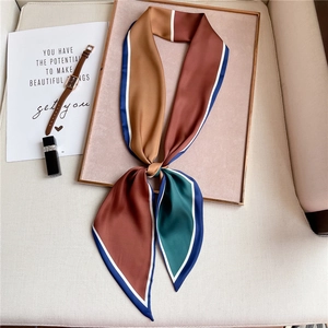 Close-up of a geometric patterned silk scarf with satin finish and fine border stitching