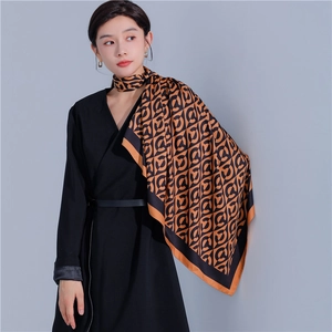 Detail of a 90cm square silk scarf with geometric orange and black chain link pattern