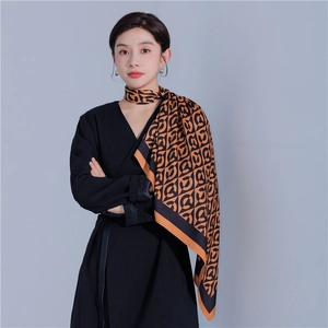 Detail of elegant orange and black silk scarf with geometric pattern and smooth texture