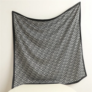 Detailed view of large black and white geometric pattern silk scarf with premium borders