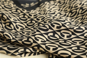 Detailed view of luxury twill silk scarf with beige and black geometric G patterns