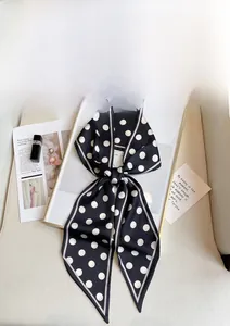 French chic polka dot skinny silk scarf styled with fashion magazine on a golden frame