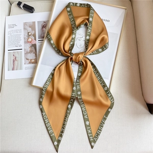 Elegant mustard yellow silk scarf with floral patterns displayed on a white frame background