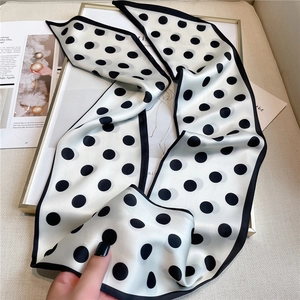 Detailed view of white polka dot silk scarf texture on magazine and frame