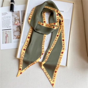 Close-up of olive green silk twilly scarf with yellow borders and floral rose patterns