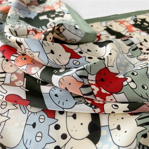 Detailweergave van zijdezachte satijnen sjaal met kleurrijke cartoon kattenillustraties