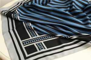Detail of silk-like geometric striped scarf with a smooth finish and elegant blue pattern