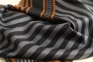 Detailed view of striped twill silk scarf showing fine texture and sleek sheen