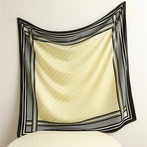 Detail of yellow and black geometric twill silk scarf showing draped satin texture