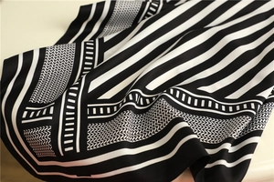 Detail of black and white geometric silk scarf with striped patterns and twill texture