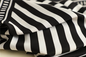 Detailed view of striped twill silk scarf with elegant glossy texture and smooth drape