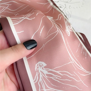 Détail d'un foulard en soie rose avec motifs de méduses et texture sergé douce