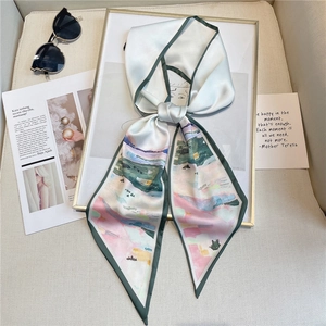 Détail d'un foulard en soie au motif aquarelle abstrait noué sur un cadre doré