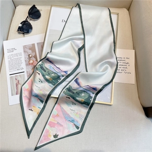 Détail d'un foulard twilly en soie avec paysage abstrait et bordure vert foncé