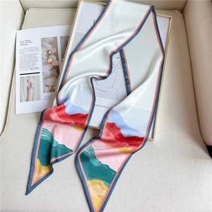 Détail d'un foulard en soie avec motifs de montagnes et bordures géométriques