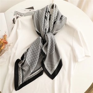 Classic houndstooth silk scarf with black and white geometric pattern over white tee