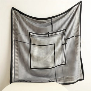 Detail of elegant black and white houndstooth silk scarf with geometric border and fine edges