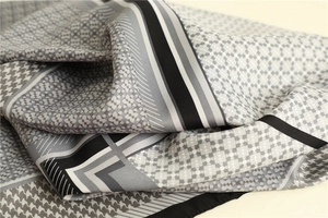 Detail of silk satin scarf featuring houndstooth pattern and geometric color blocking texture