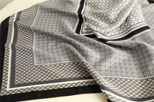 Close-up of black and white houndstooth silk scarf showing smooth texture and geometric border