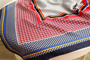 Detail of colorful houndstooth silk scarf showing smooth satin texture and vibrant patterns