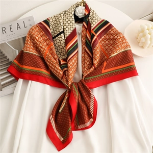 Elegant houndstooth silk-like scarf with vibrant red, orange, and olive geometric patterns