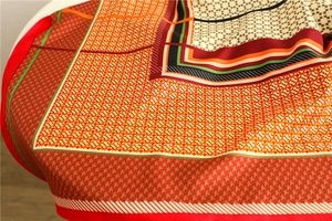 Detailed close-up of houndstooth pattern and geometric print on satin silk scarf