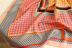 Macro shot of houndstooth silk scarf with geometric stitching and vibrant color blocks