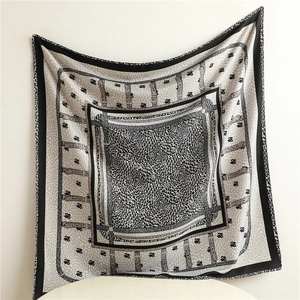 Detailed view of fish-scale pattern silk scarf with belt design and rolled edges