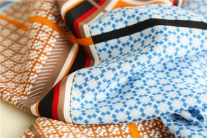 Close-up of silk-textured twill scarf with houndstooth pattern and elegant color-block edges