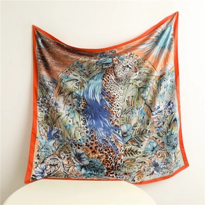 Detail of a square silk scarf with leopard, blue feathers, and solar jungle patterns